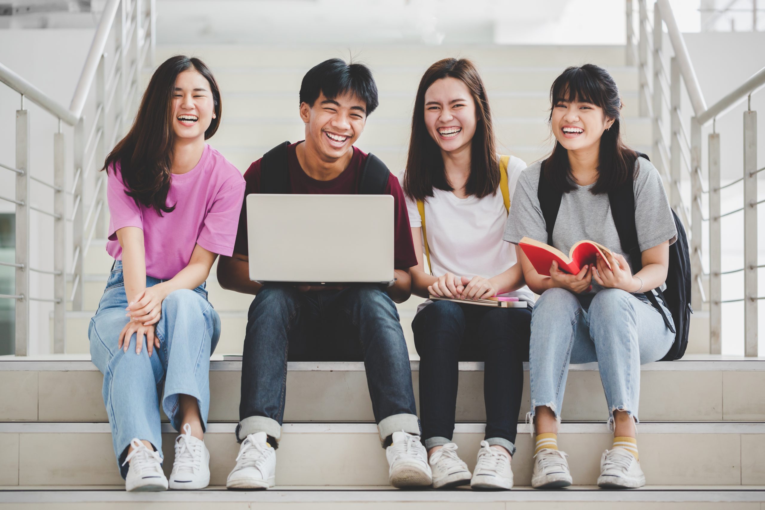Education concept - Group of cheerful students sat on the floor